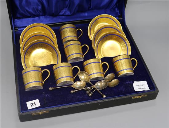 A set of six Limoges blue edged gilt porcelain coffee cans and saucers, together with a set of six silver gilt spoons, cased